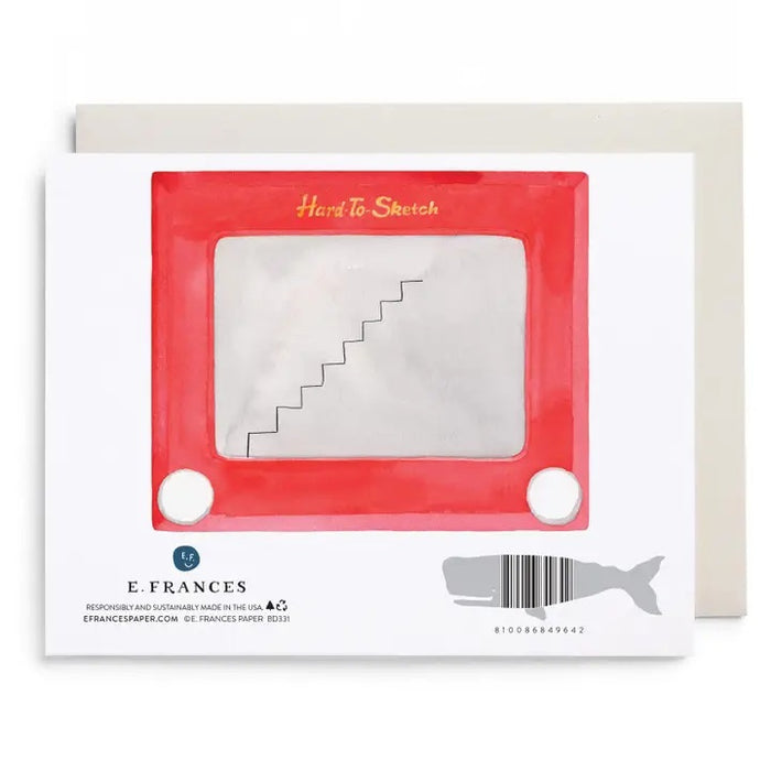 The E. FRANCES - HARD TO SKETCH BIRTHDAY CARD by E. FRANCES PAPER features an Etch A Sketch illustration with the message "happy birthday this is taking forever" drawn in the toy’s iconic line style, and comes with an envelope placed behind the card.