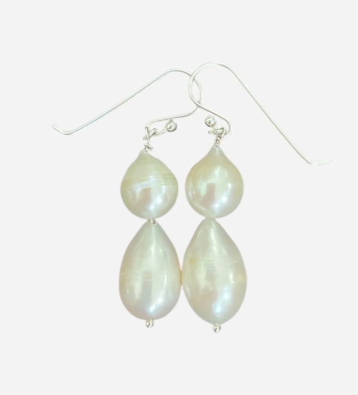 The ANN LIGHTFOOT - DOUBLE DROPLET FRESHWATER PEARL EARRINGS feature teardrop-shaped white pearls on sterling silver hooks, shown against a plain white background.